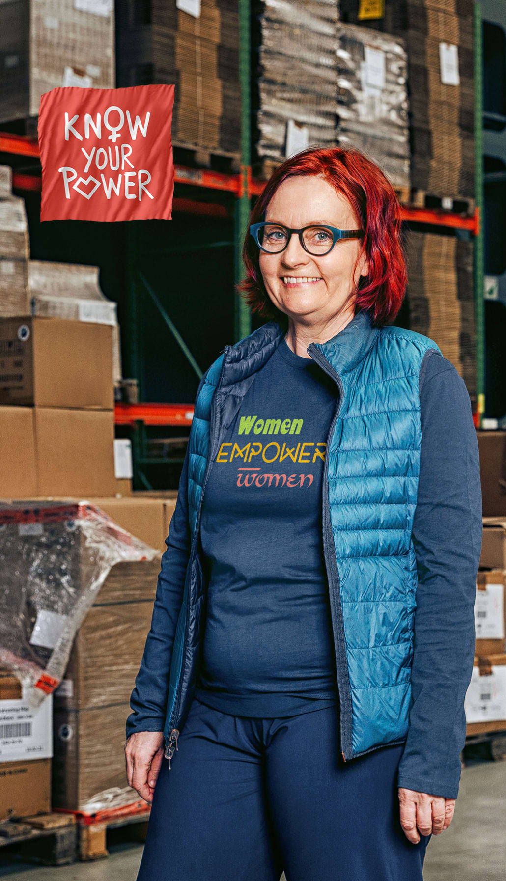 Hanne in einem Auslieferungslager trägt ein langärmeliges T-Shirt mit einem Motiv: women empower woman